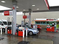 Gas station with fuel pumps and convenience store in Exeter.