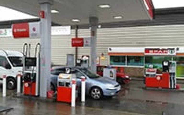 Gas station with fuel pumps and convenience store in Exeter.
