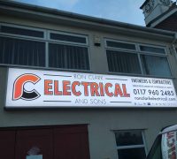 Commercial electrical sign for Ron Clark Electrical on building facade.