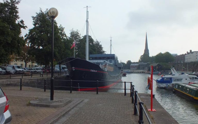 Boat docked at the harbor with electrical infrastructure in the background.